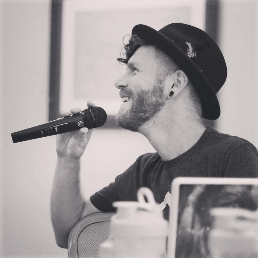Tala Sage speaking into a handheld mic, black and white