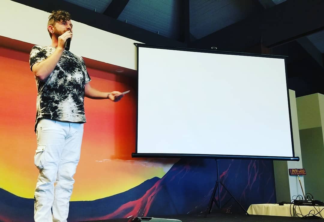 Tala Sage presenting beside a projection screen