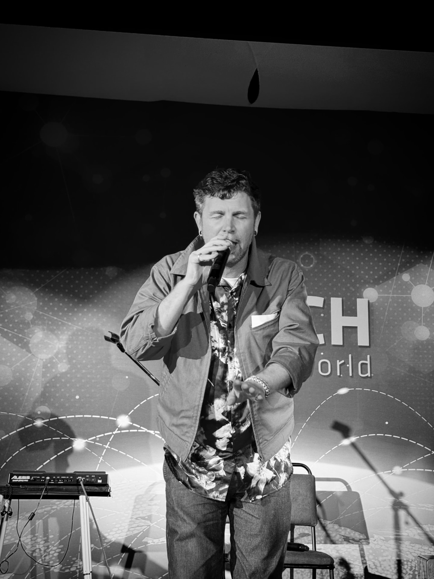 Tala Sage speaking at a tech conference, black and white